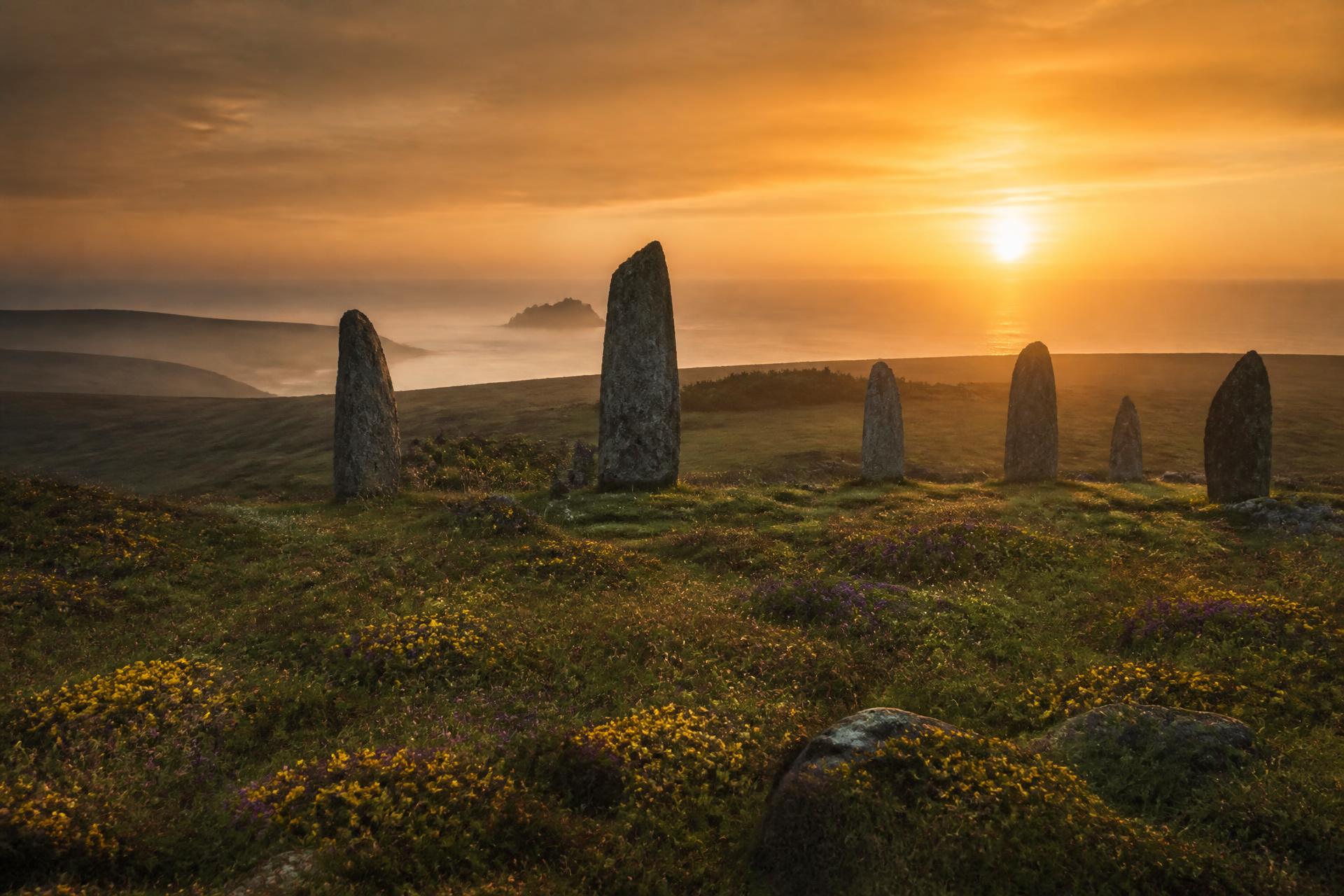 Sunset over an ancient Cornish stone circle above the sea